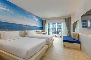 Ein Hotelzimmer mit zwei Betten, einem Balkon mit Meerblick und einem an der Wand befestigten Fernseher.