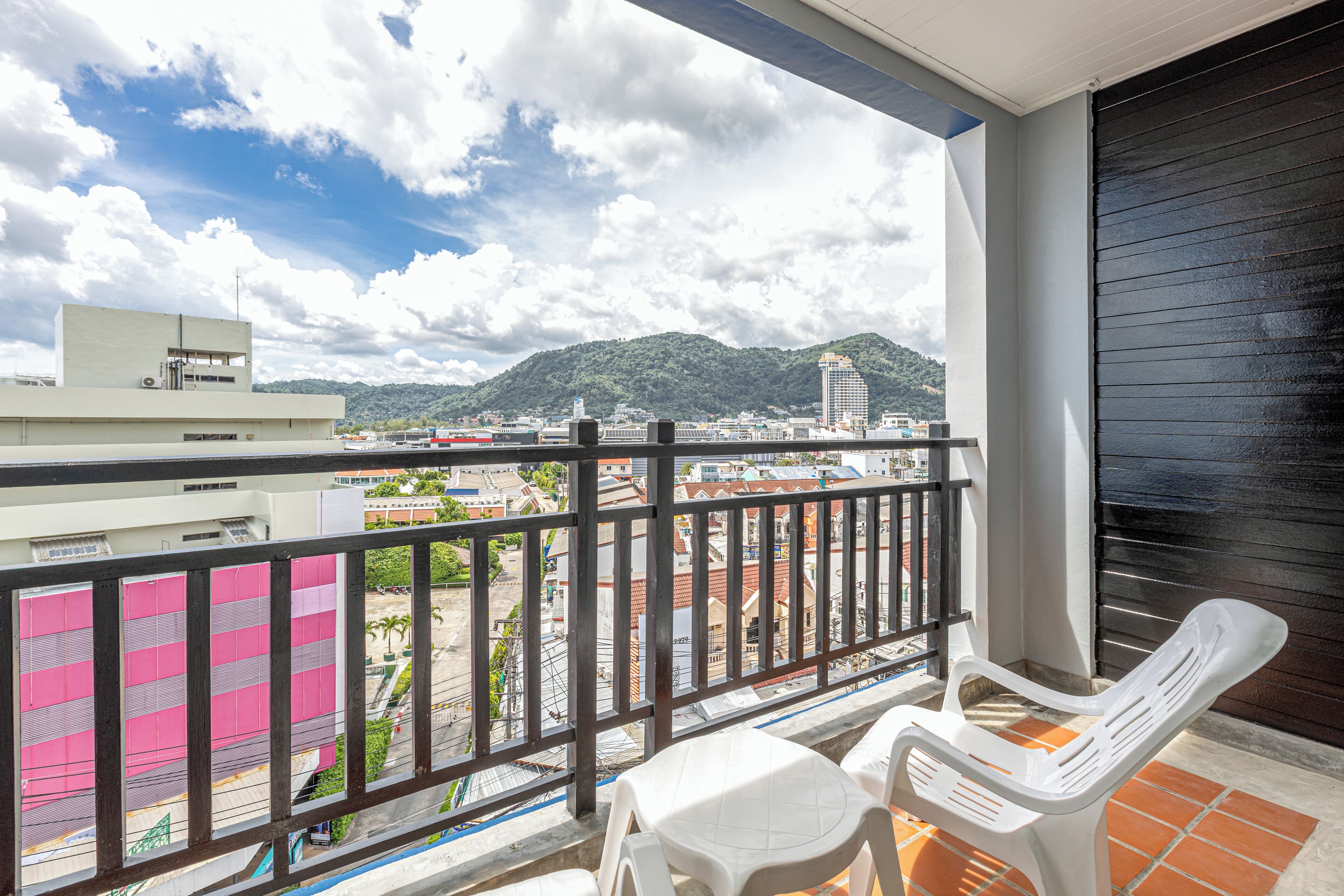 Un balcón con vistas a un paisaje urbano y montañas.