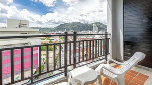 A balcony with a view of a cityscape and mountains. - Amata Patong (Patong)
