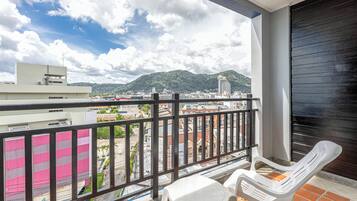 Un balcón con vistas a un paisaje urbano y montañas.