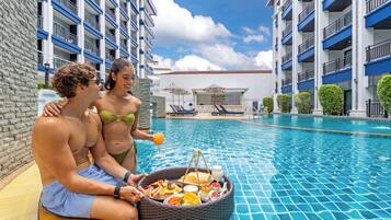 A swimming pool area with a bar and lounge chairs.