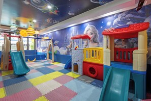 A children's play area with a slide, play structures, and a wall mural. - Amata Patong (Patong)