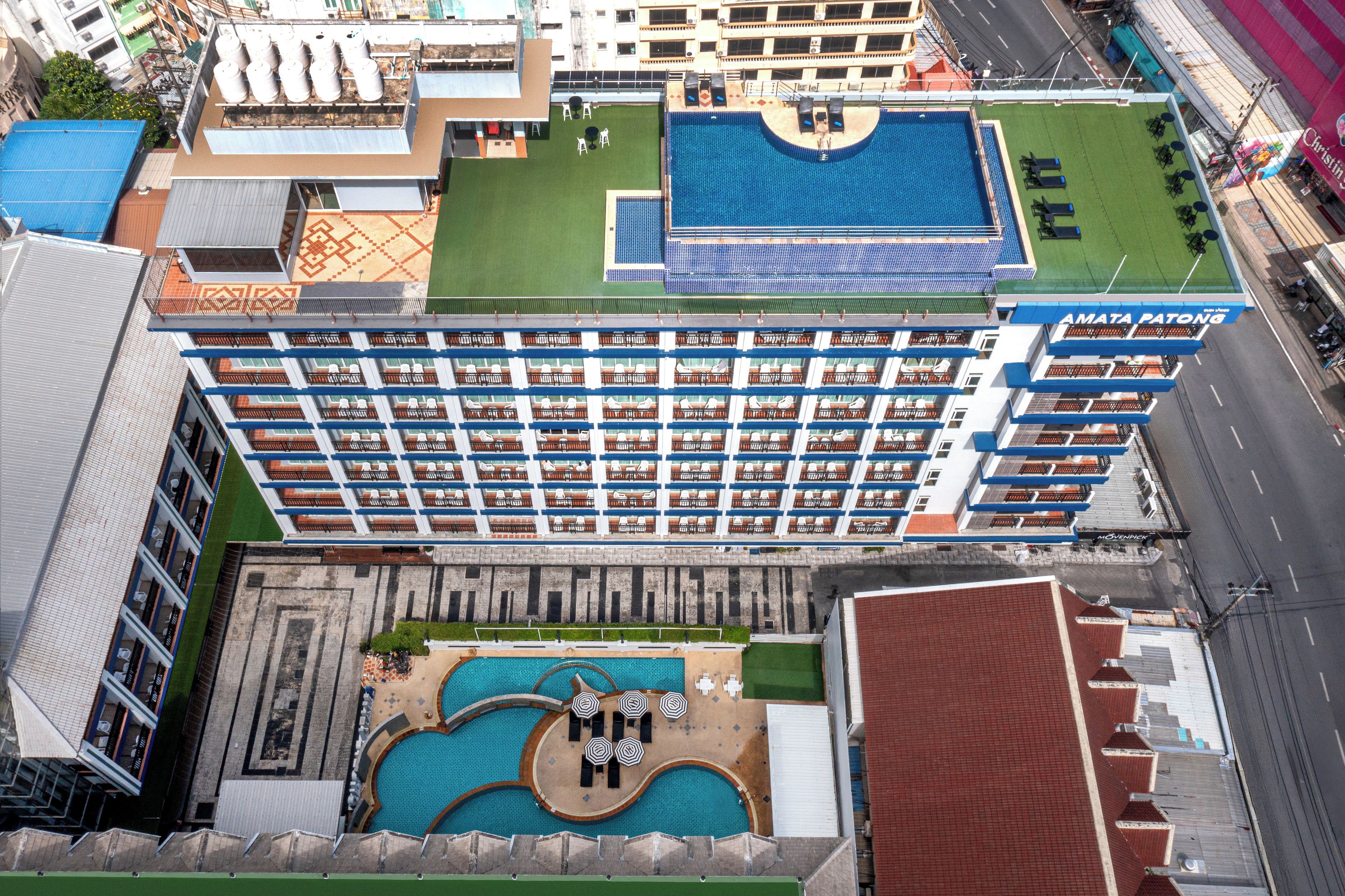 A high-rise hotel with multiple balconies, a rooftop pool, and a landscaped terrace.