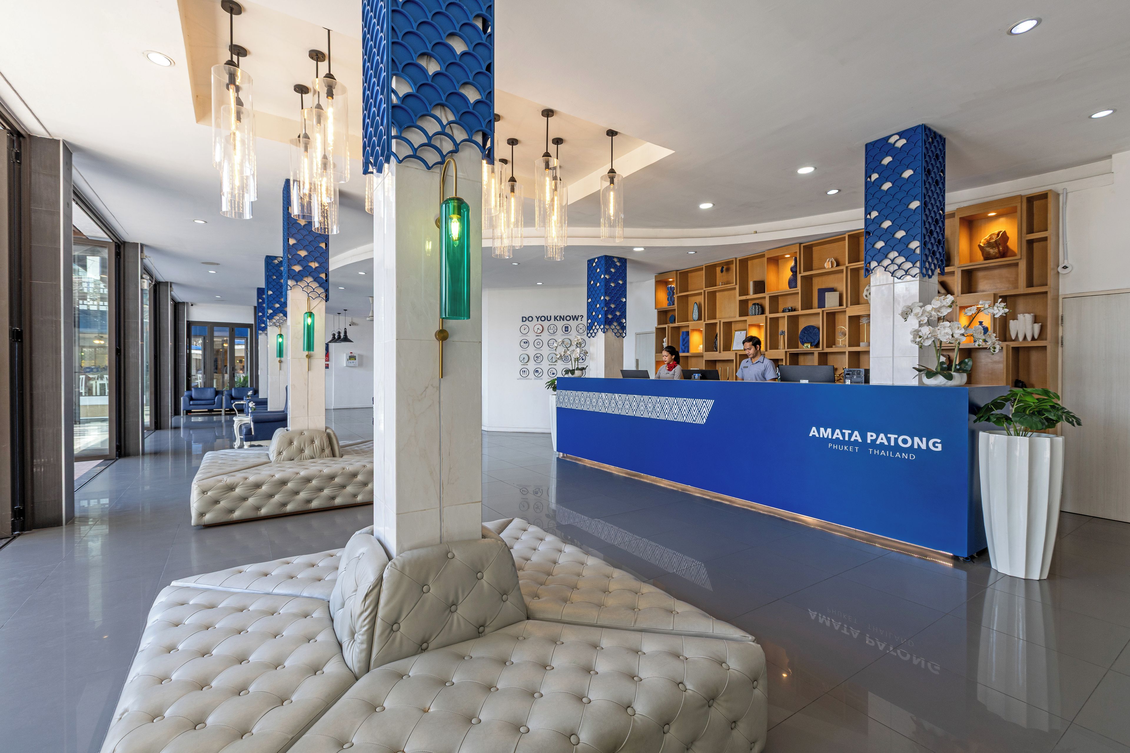 A modern reception area with a blue reception desk, seating, and a decorative ceiling.