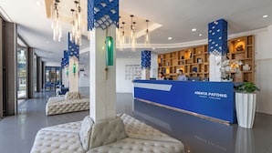 A modern reception area with a blue reception desk, seating arrangements, and decorative lighting. - Amata Patong (Patong)