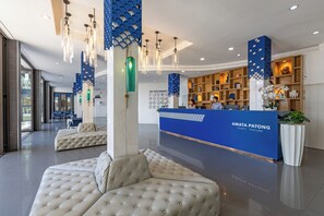A modern reception area with a blue reception desk, seating arrangements, and decorative lighting.