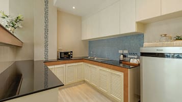 Een moderne keuken met een zwart aanrecht, een magnetron en een spoelbak.