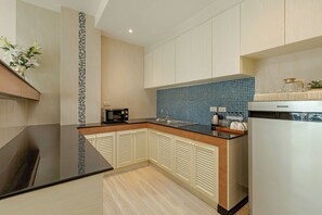 A modern kitchen with a black countertop, a microwave, and a sink.