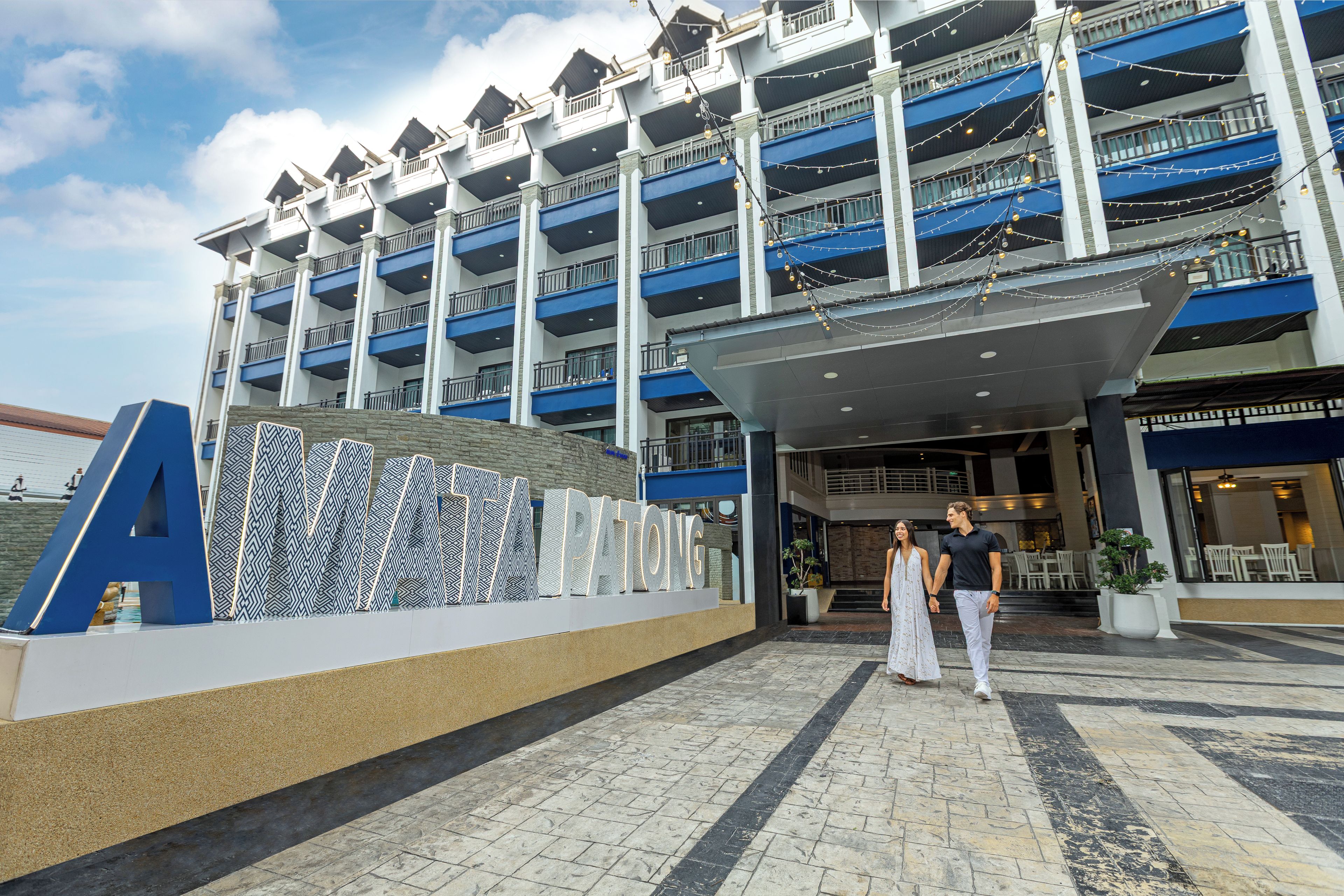 A multi-story hotel with a prominent 'A' sign, a covered entrance, and a pool area.