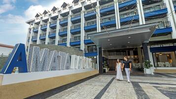 A multi-story hotel with a prominent 'A' sign, a covered entrance, and a pool area.