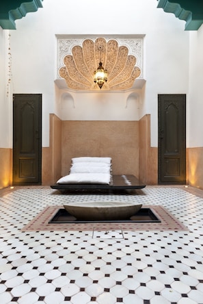 A room with a bed, a decorative wall, and a patterned floor.
