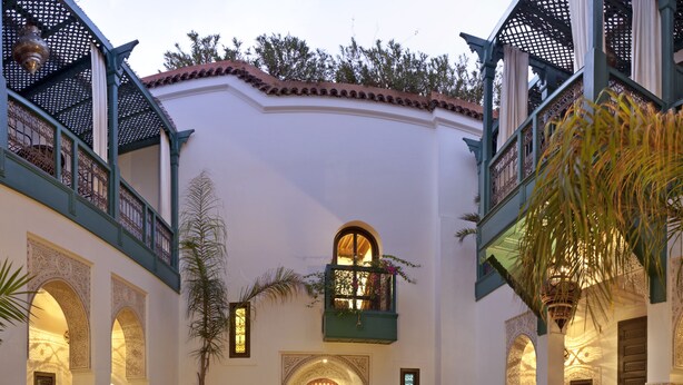 A courtyard with a pool, ornate arches, and a balcony. - Le Farnatchi (Marrakech)
