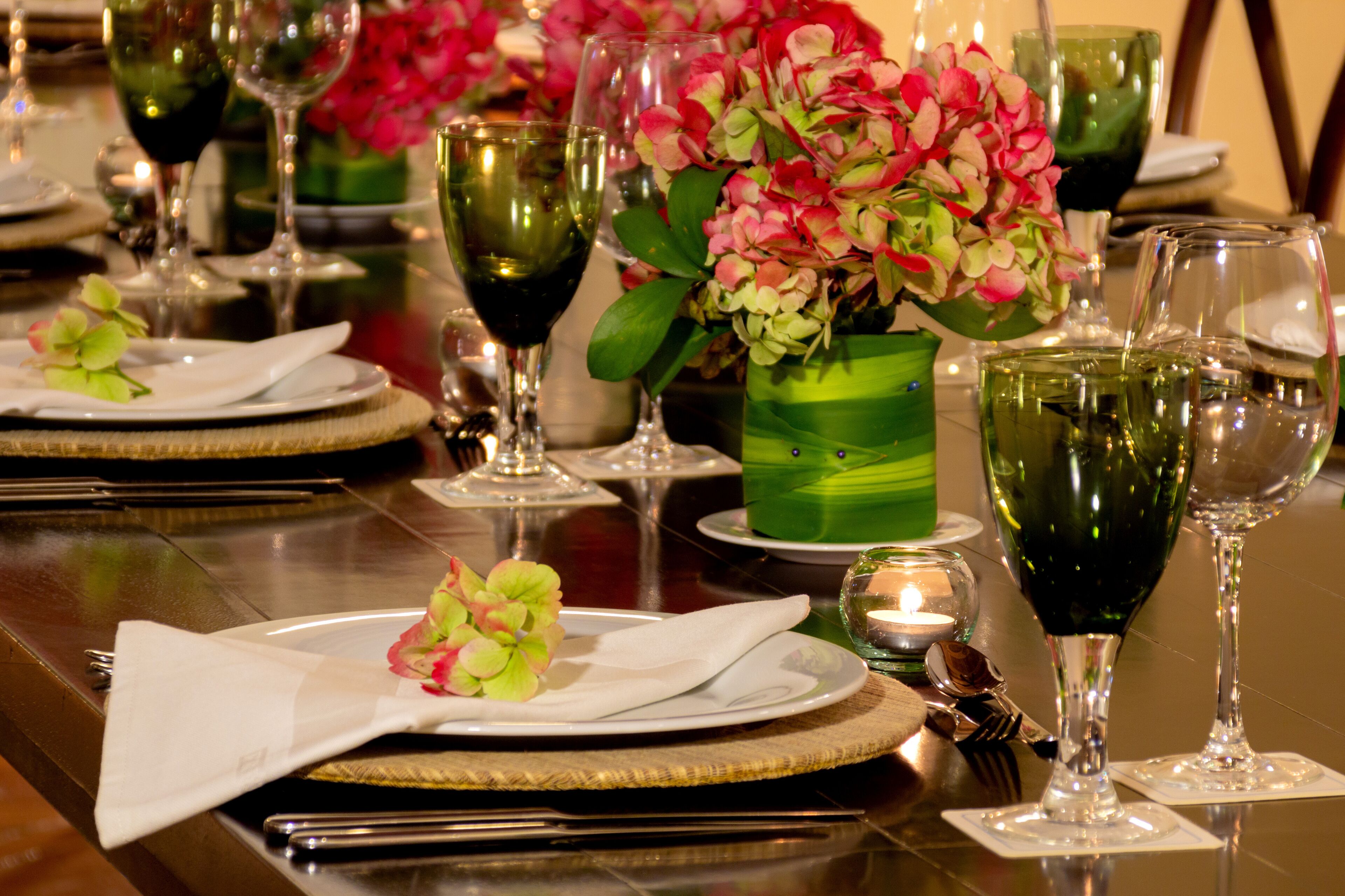 A table set for dining with plates, cutlery, and wine glasses.