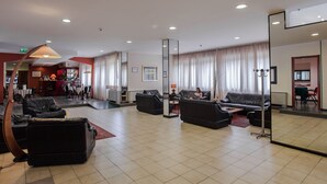 Un vestíbulo amplio con varias zonas de estar, un bar y un comedor.