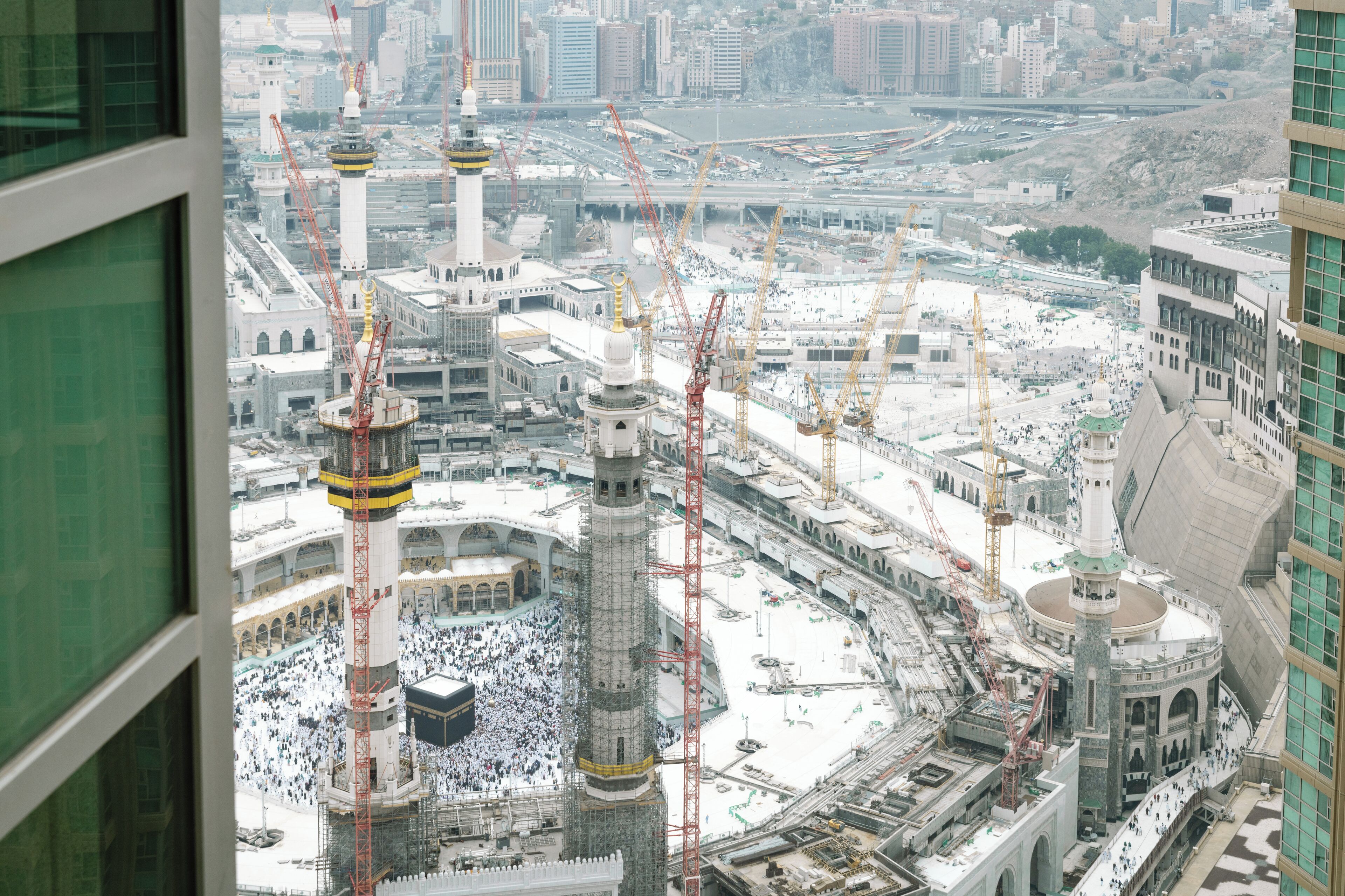 A view of a large mosque with multiple minarets and a central courtyard.
