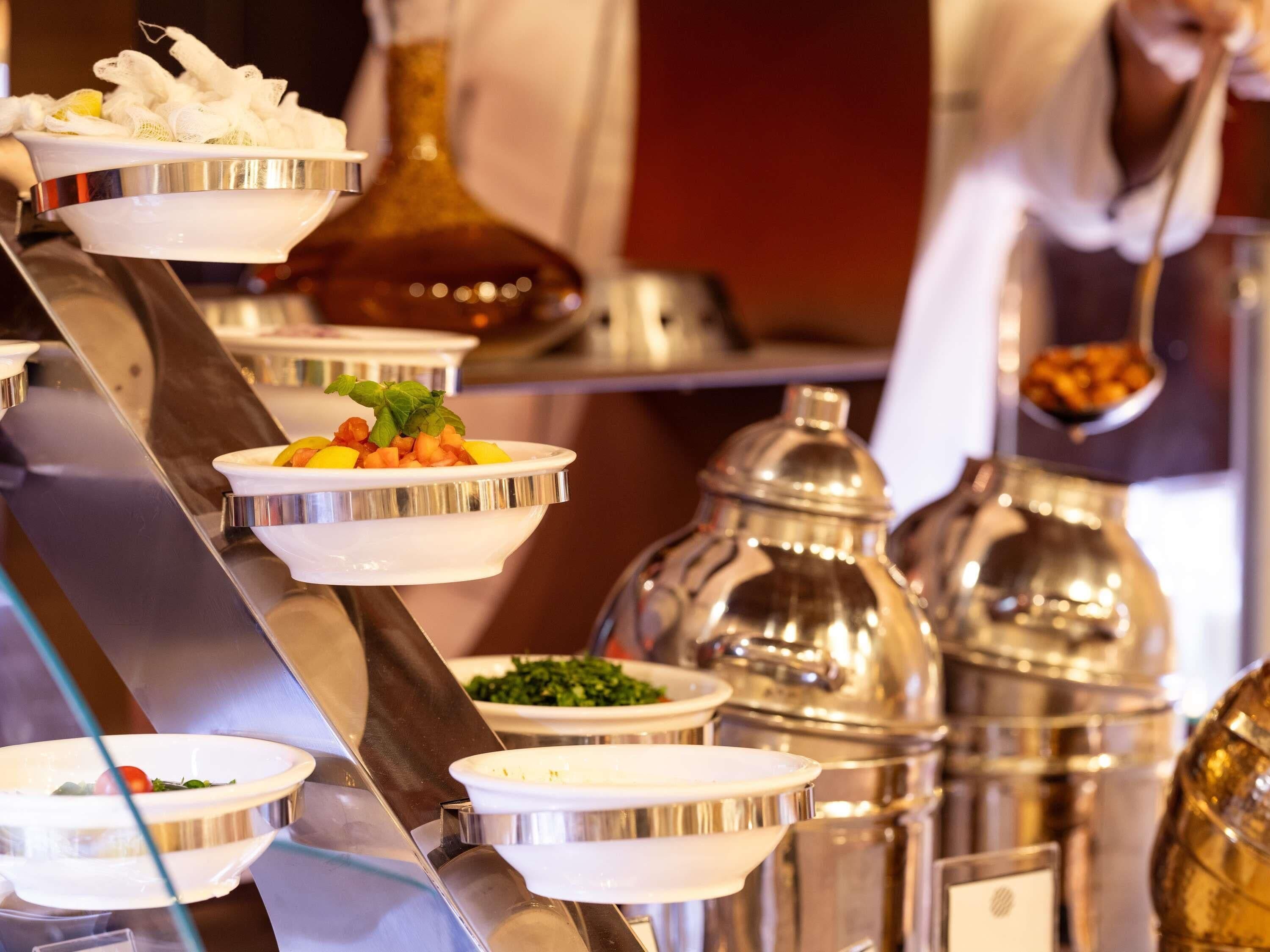 A buffet setup with multiple serving stations, including bowls of food and various containers.