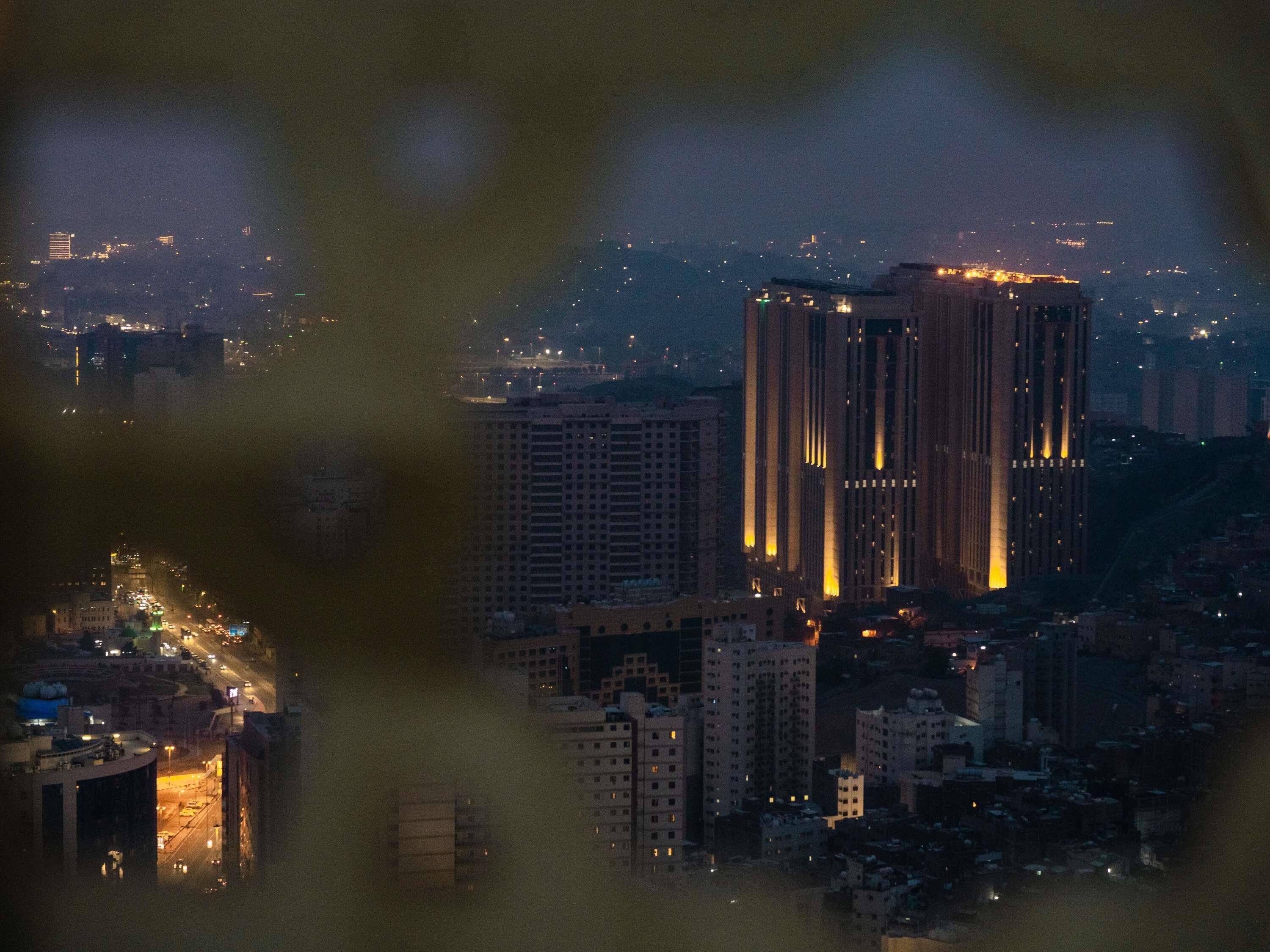 A nighttime cityscape with high-rise buildings and illuminated windows.