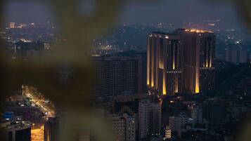 A nighttime cityscape with high-rise buildings and illuminated windows.