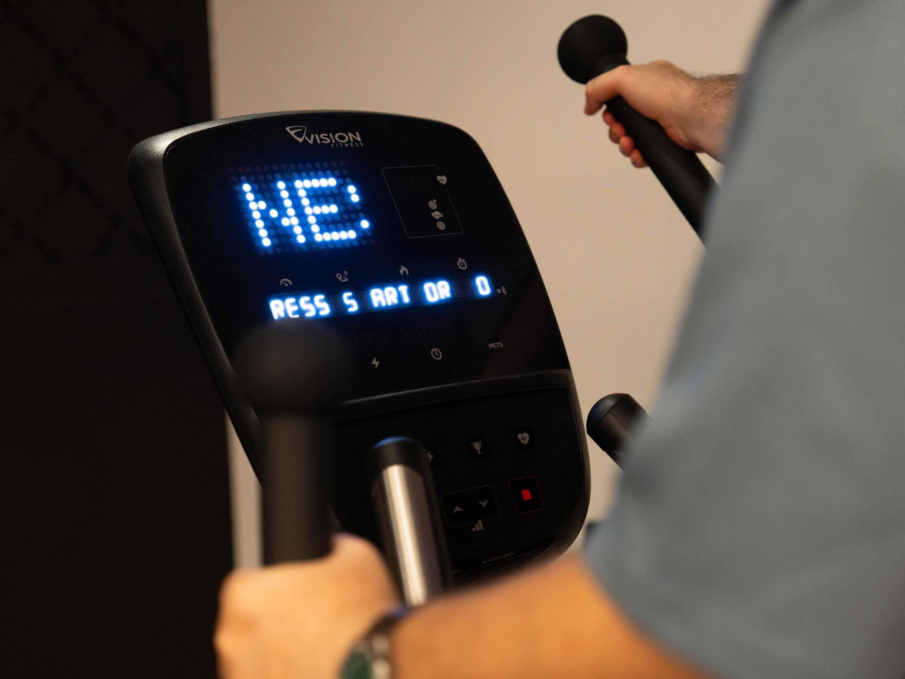Un écran numérique intégré à un appareil de musculation de la marque « VISION FITNESS ».