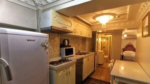 A compact kitchen with a refrigerator, microwave, stove, and sink. - Romantic Mansion (Istanbul)