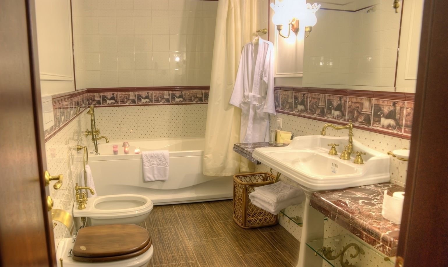 A bathroom with a bathtub, two sinks, a toilet, and a mirror.