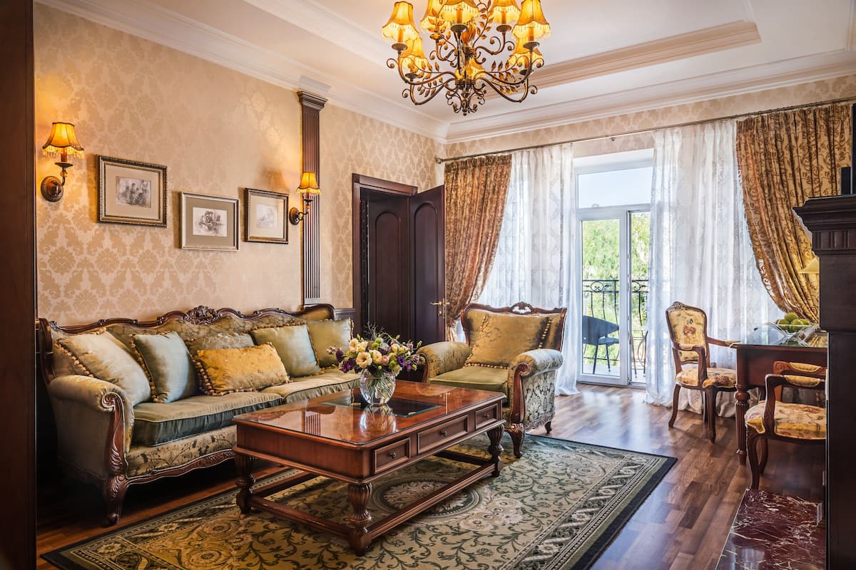 A traditional living room with a sofa, armchairs, a coffee table, and a chandelier.