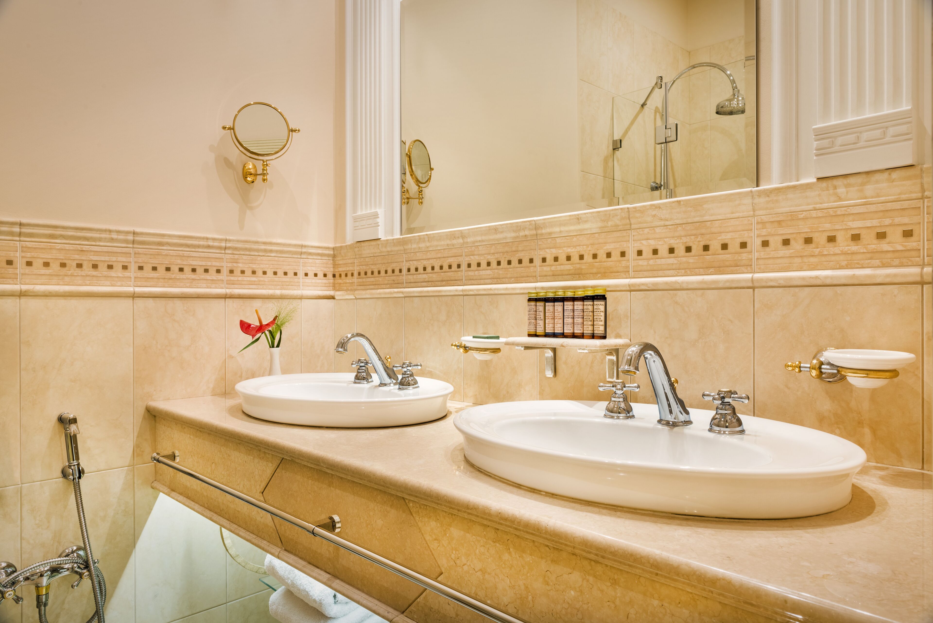 A bathroom with two sinks, a shower, and a large mirror.
