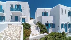 A white building with blue shutters and a stone staircase. - Castellano Village (Astypalaia)