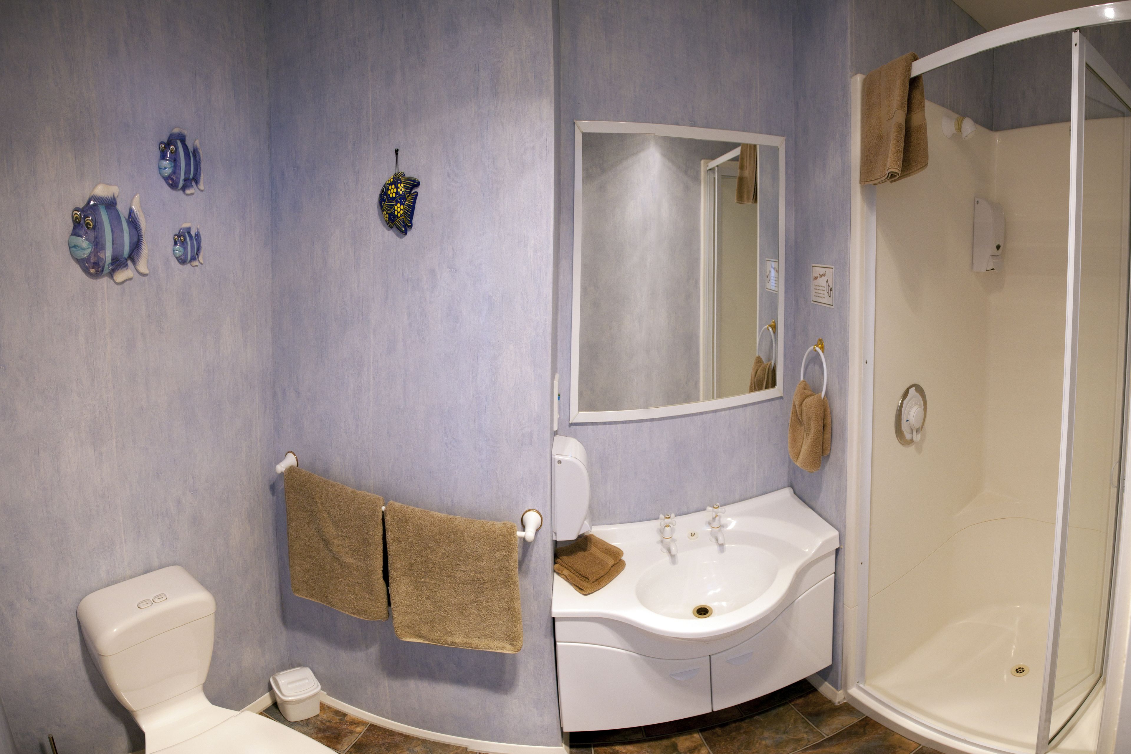 A bathroom with a toilet, sink, and shower.