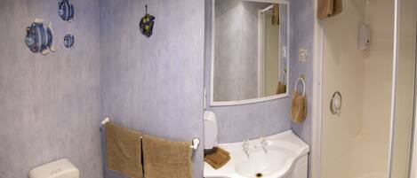 A bathroom with a toilet, sink, and shower.