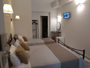 Habitación triple básica, varias camas, baño privado, planta baja | Caja fuerte, escritorio, cortinas opacas y tabla de planchar con plancha