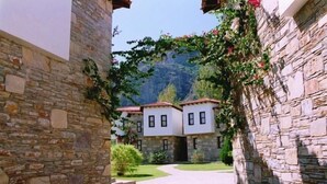A stone building with a courtyard and a mountain in the background.