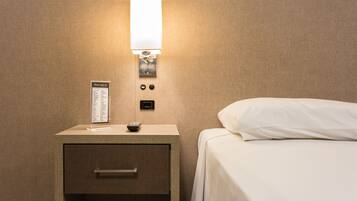 Habitación de hotel con una cama, una mesita de noche con lámpara, un control remoto y un cartel con el menú.