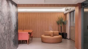 Un interno moderno con zona pranzo, angolo salotto e un'ampia finestra con tende.