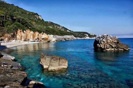 Una playa cerca, sillas reclinables de playa, sombrillas