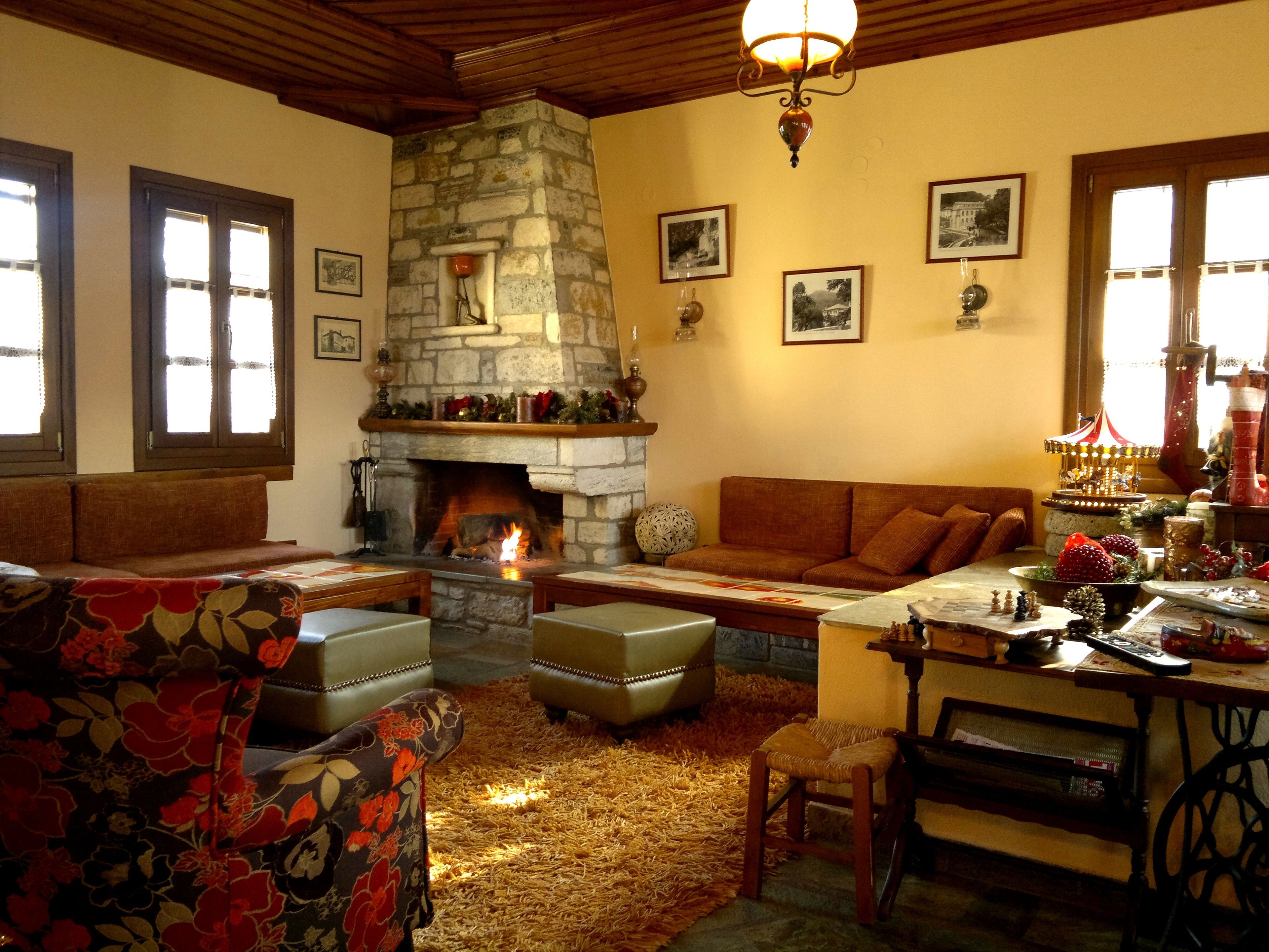 Una sala de estar acogedora con chimenea de piedra, asientos cómodos y decoración navideña.