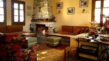 Una sala de estar acogedora con chimenea de piedra, asientos cómodos y decoración navideña.