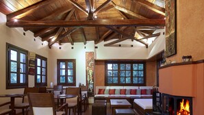 A cozy interior with wooden beams, a fireplace, and seating areas. - Aleka's House (Zagora-Mouresi)