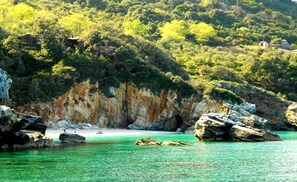 Playa en los alrededores, camastros, sombrillas y toallas de playa 