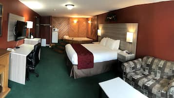 Une chambre d’hôtel équipée d’un lit, d’un canapé, d’un bureau, d’une télévision, d’un four à micro-ondes et d’un espace douche.