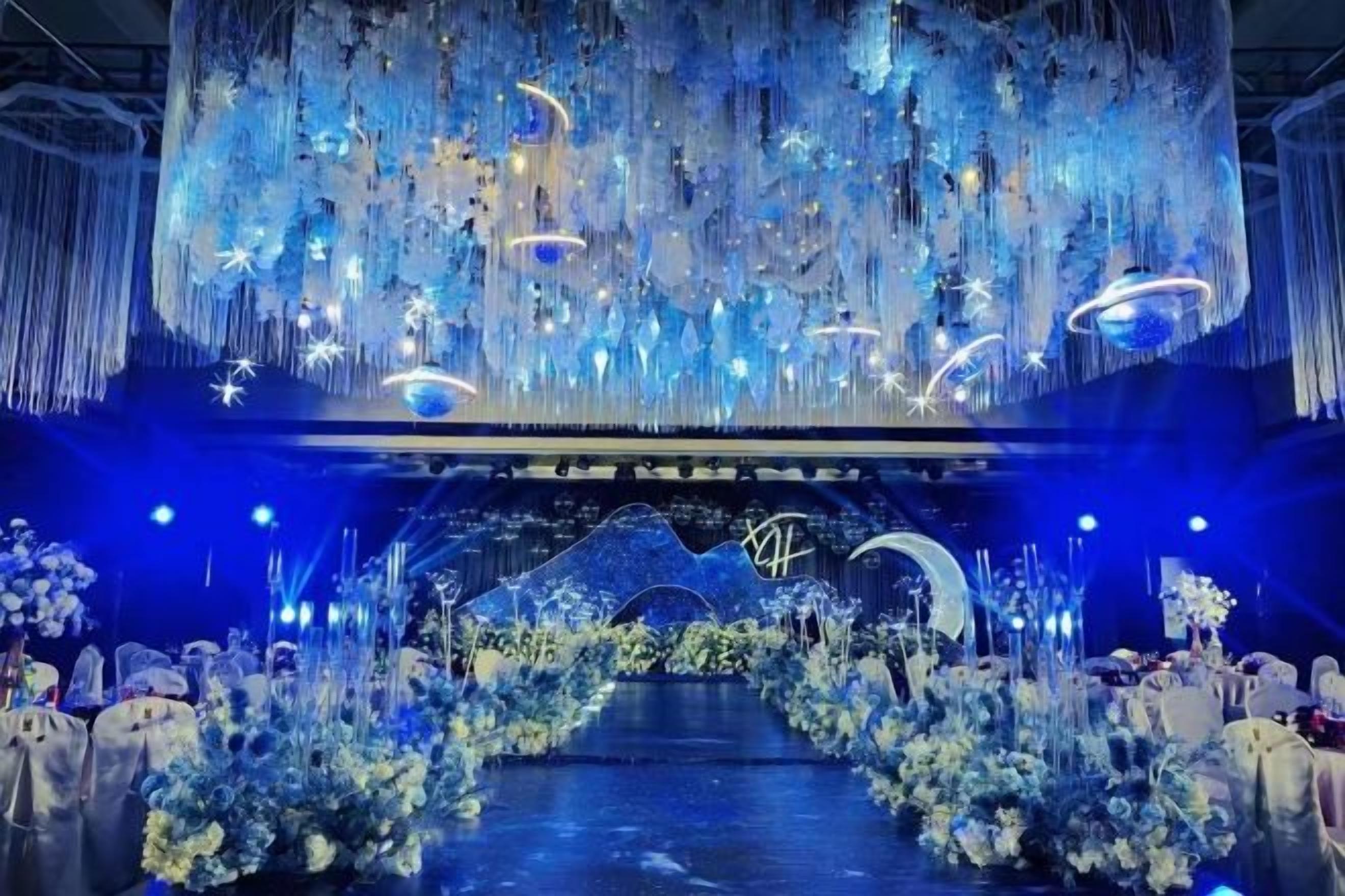 A stage with a floral archway and hanging decorations.