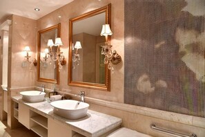 A bathroom with two sinks, large mirrors, and wall sconces. - Xintian International Hotel (Xiangtan)