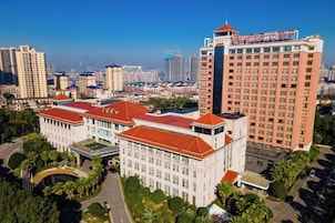 A multi-story building with a red roof and a large central entrance.