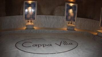 A circular stone floor with the inscription "Cappa Villa" and two wall-mounted sconces with decorative glass panels.