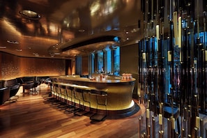A modern bar area with a curved counter, bar stools, and a decorative wall feature. - Mandarin Oriental, Paris (Paris)