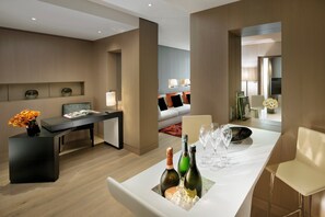 Ett modernt hotellrum med en matplats, en soffa, en TV och en minibar.