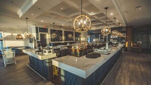 A spacious bar area with a marble countertop, hanging spherical light fixtures, and a wooden floor. - Prestige Oceanfront Resort, WorldHotels Luxury (Sooke)