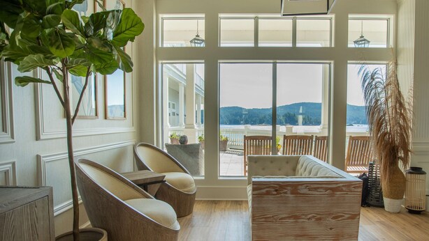 A spacious room with large windows, a wooden floor, and a view of a balcony and mountains. - Prestige Oceanfront Resort, WorldHotels Luxury (Sooke)