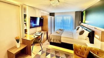 Une chambre d’hôtel équipée d’un lit, d’un bureau, d’une chaise, d’une télévision et offrant une vue sur l’extérieur.
