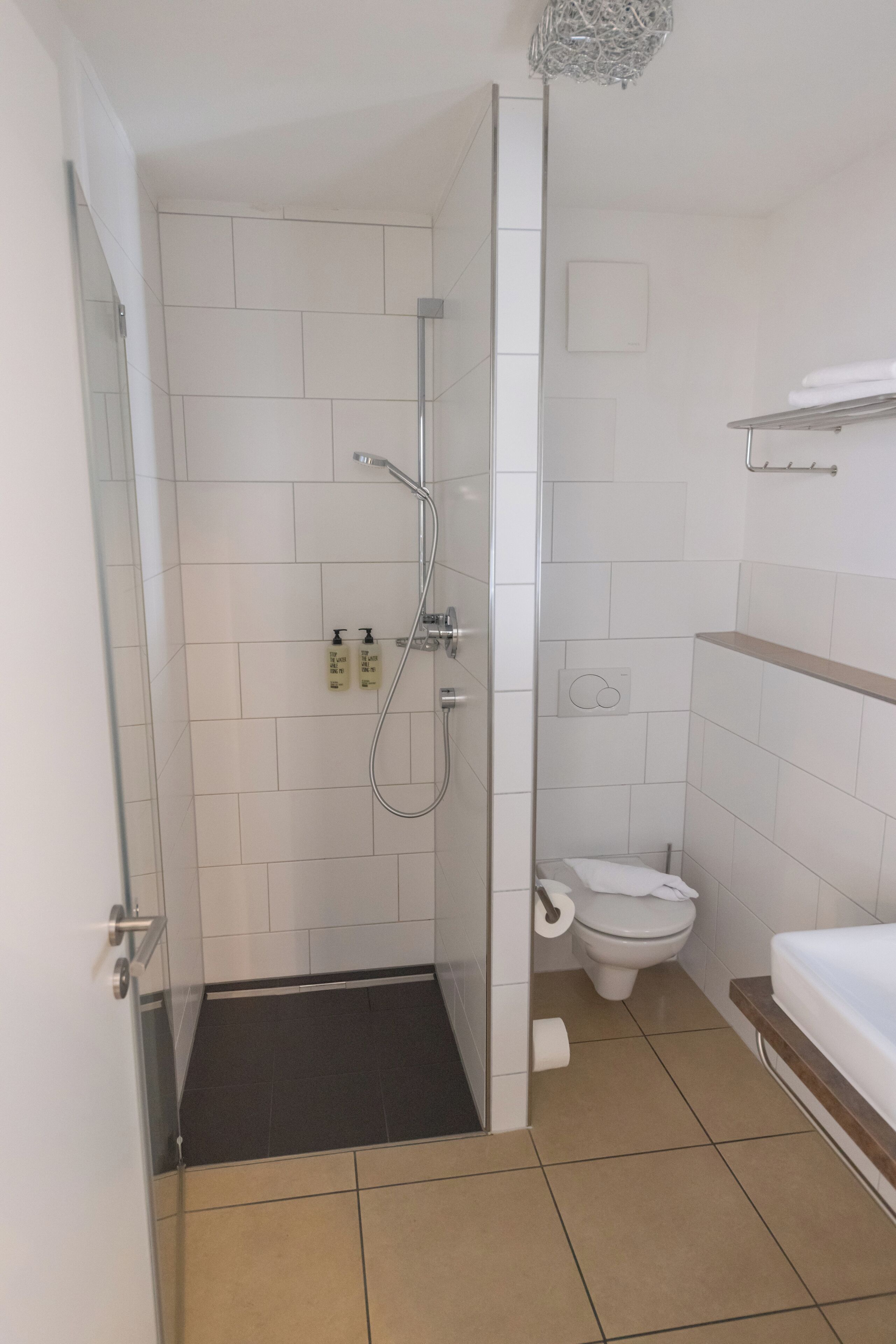 A bathroom with a shower, toilet, and sink.